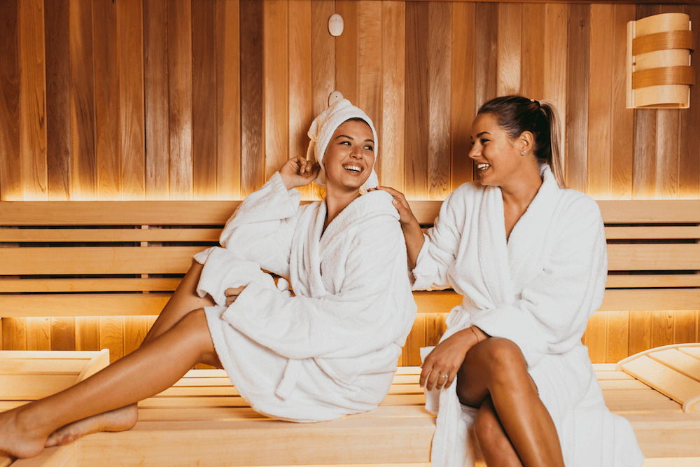 2 women laughing and having a good time in the sauna