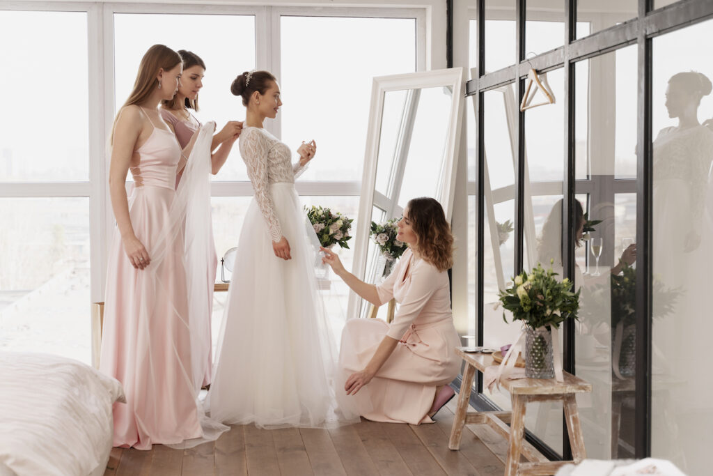 Bride and bridemaids trying dresses